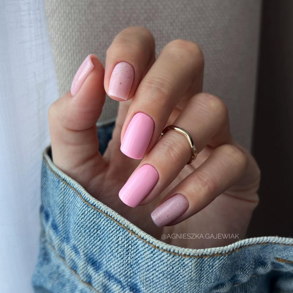 Short square nails with alternating pink and nude shades with gold micro glitter on accent nails 