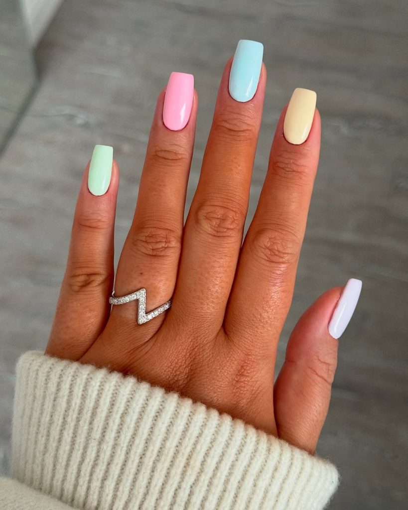 Square medium length nails in pastel colors including mint green, baby pink, light blue, pale yellow and white