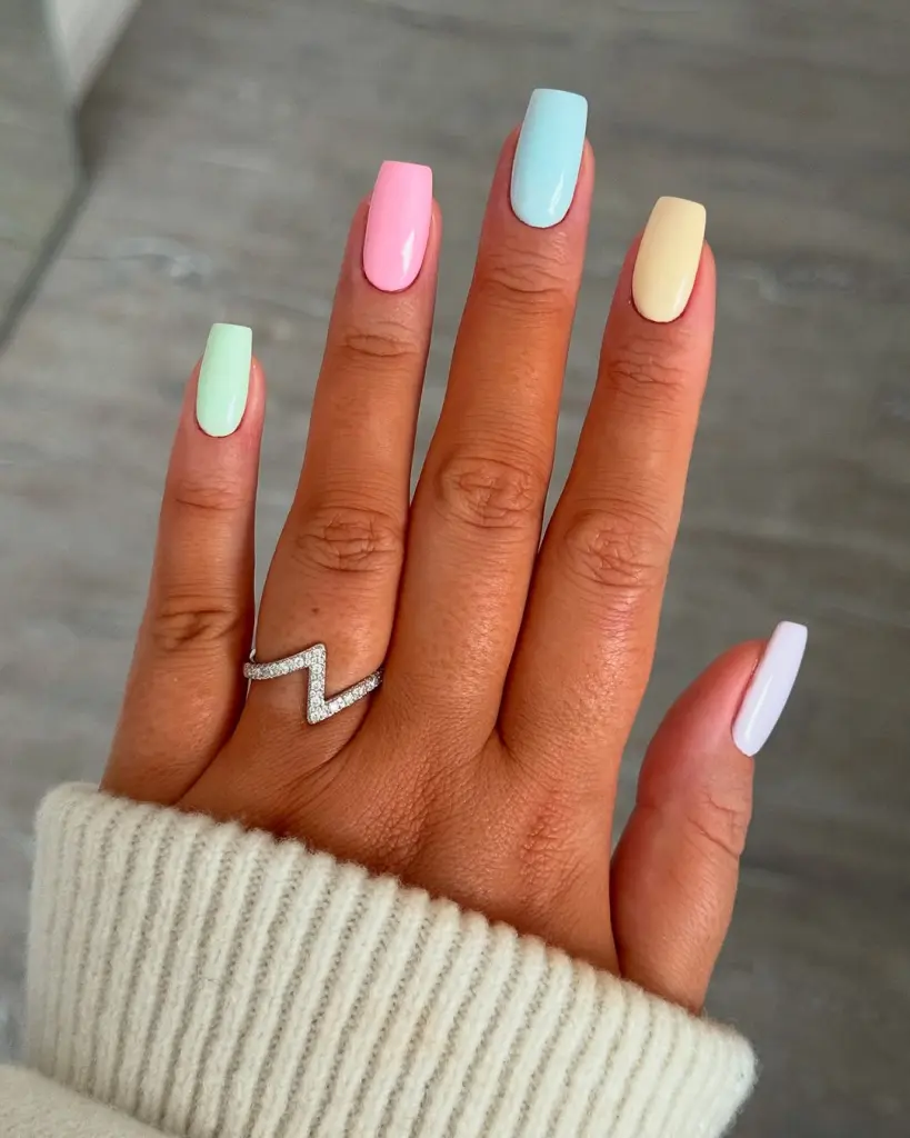 Square medium length nails in pastel colors including mint green, baby pink, light blue, pale yellow and white
