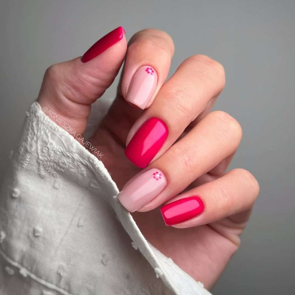 Short square nails alternating between fuchsia pink and soft pink with small dot details
