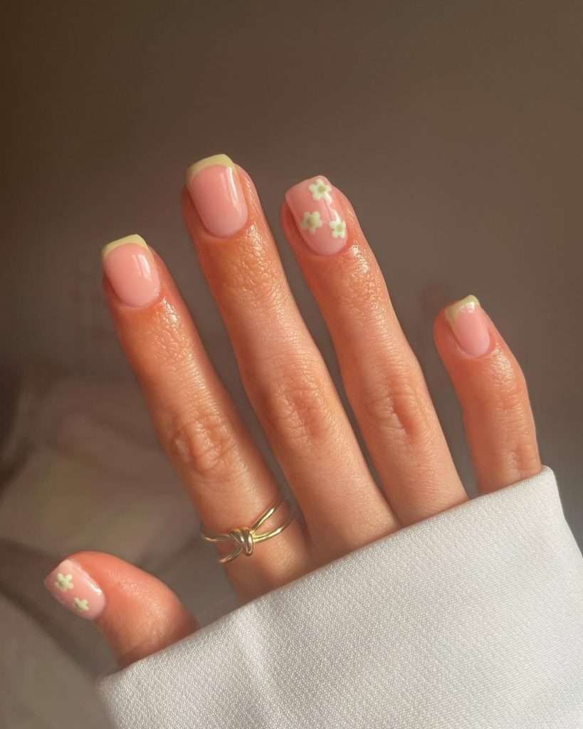 Short square nails in Sheer pink with green daisy accents and tips