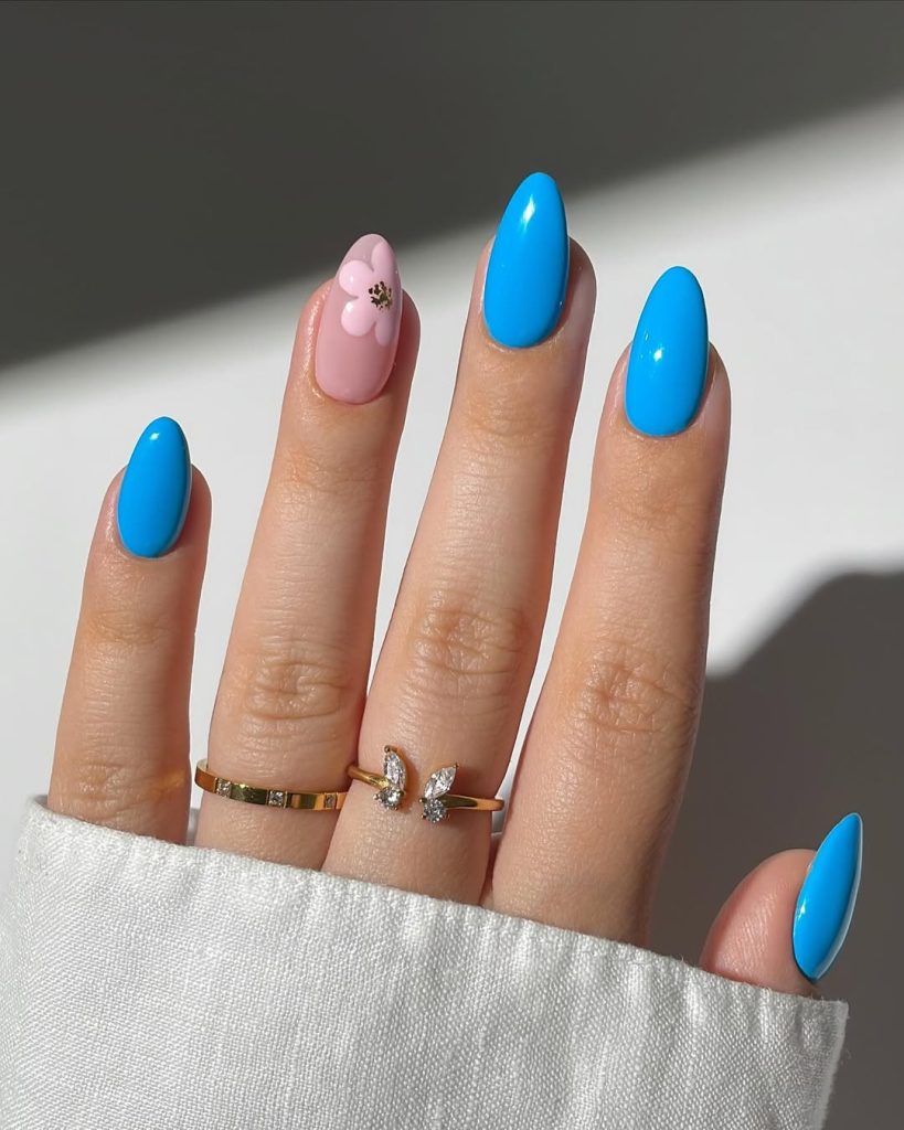 almond summer nails with bright sky blue polish and pink floral 3D accent nail design