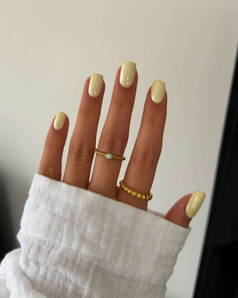 Short spring nails painted in metallic yellow chrome polish
