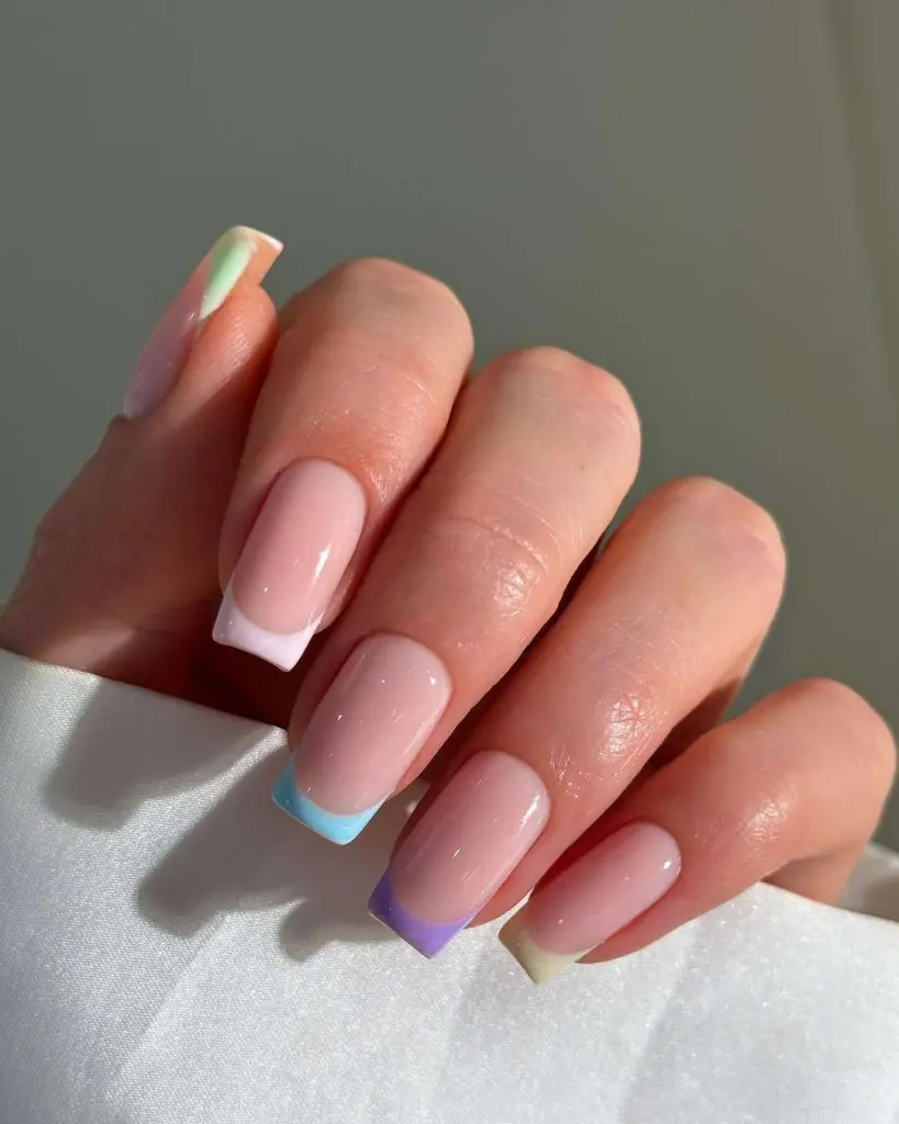 Long square pink nails with multicolored French tips in white, blue, purple and yellow pastels for vibrant spring manicure