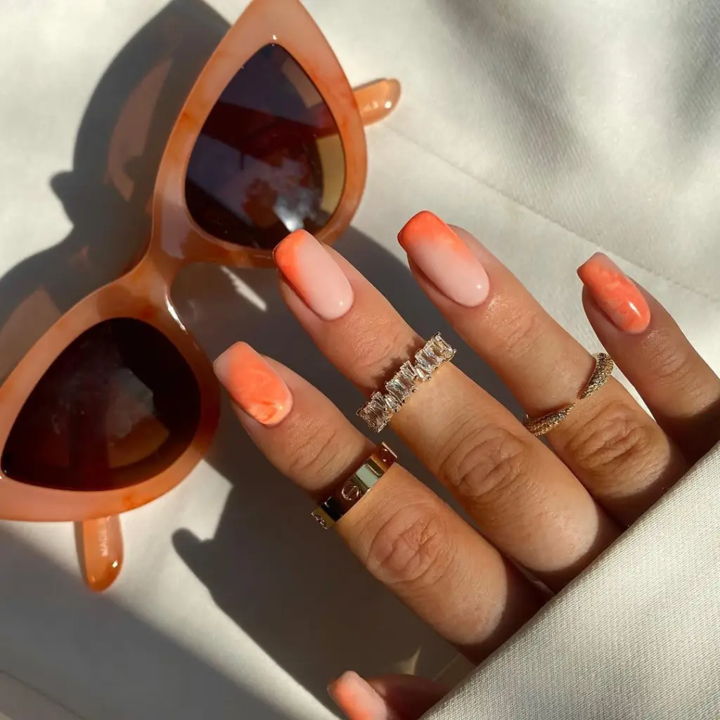 square summer nails with nude to coral ombré gradient and orange watercolor accent nail
