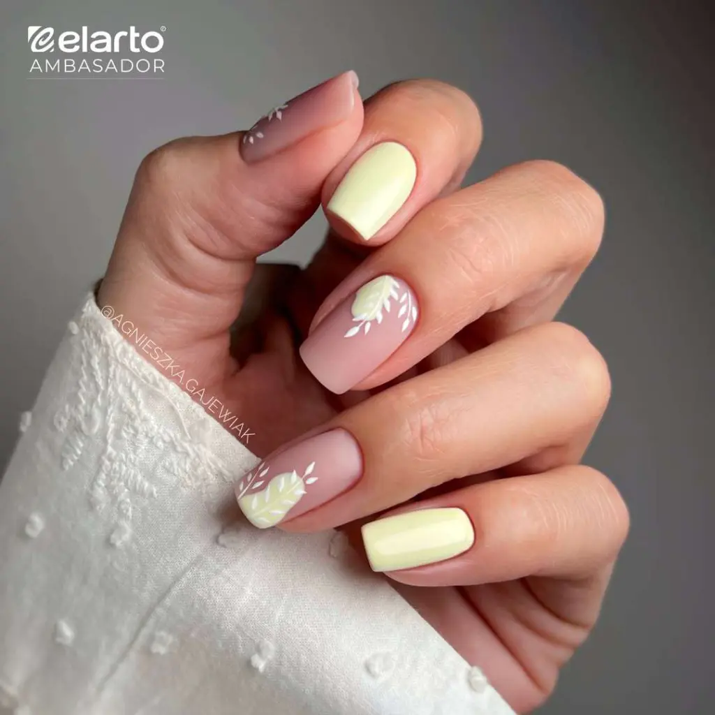 Square spring nails with pastel yellow polish and pink base with white leaf design
