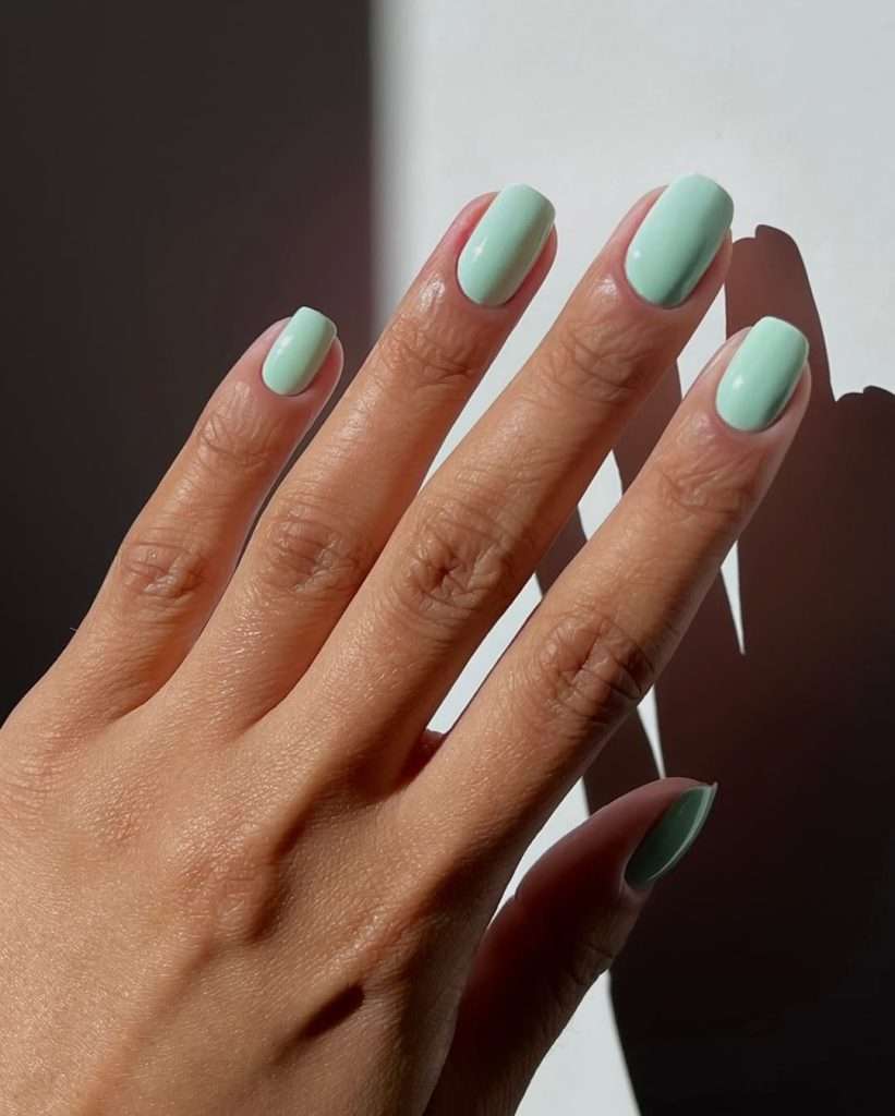 Short oval nails in mint green pastel color for clean minimalist spring manicure