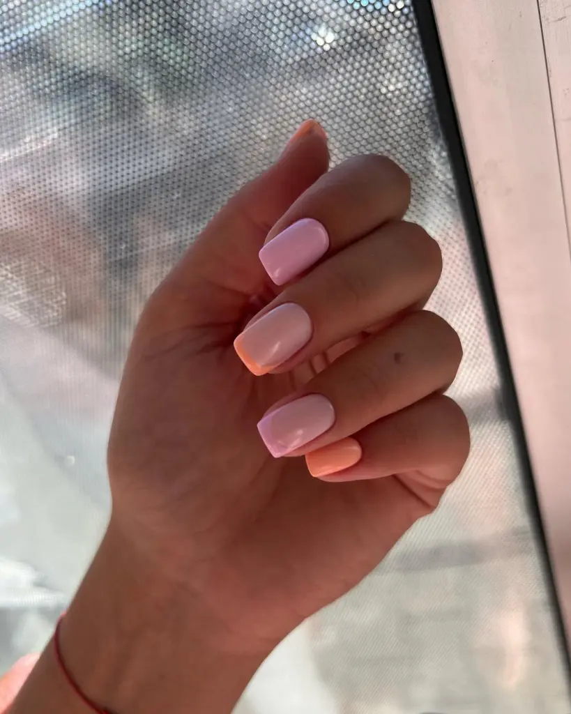 Short square summer nails with soft pink polish and peach accent nails