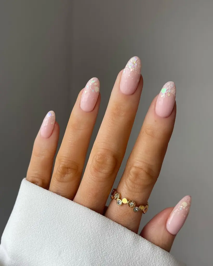 Almond shaped pink nails with iridescent glitter gradient tips
