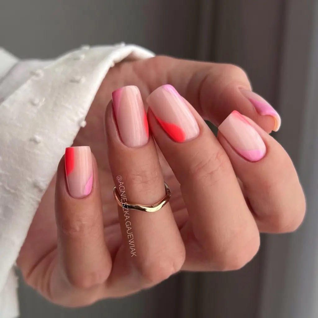 Short summer nails with transparent nude base featuring pink and coral abstract color block accents in different positions across each nail