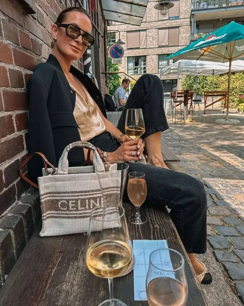 Elegant casual spring date outfit with black blazer, silk champagne camisole, black jeans, designer canvas tote and nude flats
