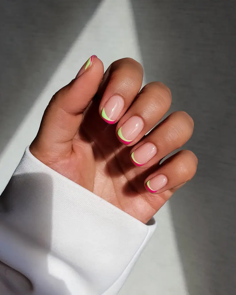 Short summer nails with clear base featuring double French tips in hot pink outer edge and lime green inner line creating a watermelon-inspired design