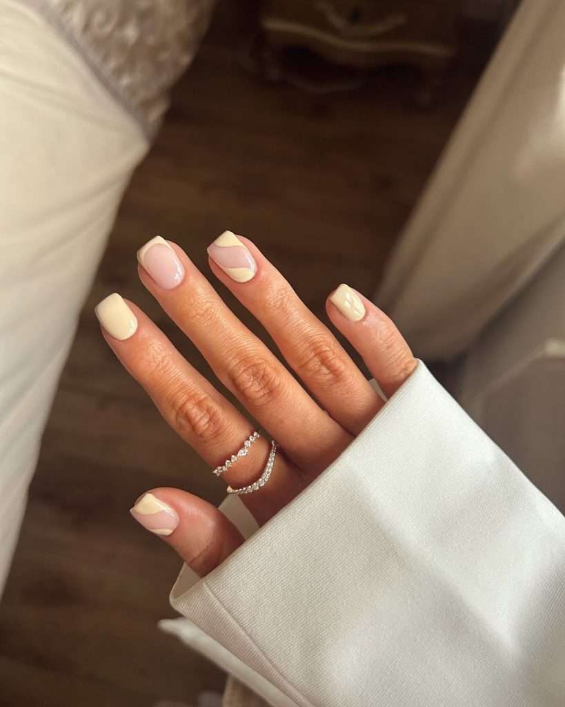 Short square nails with cream and milky white abstract swirl designs for elegant spring manicure
