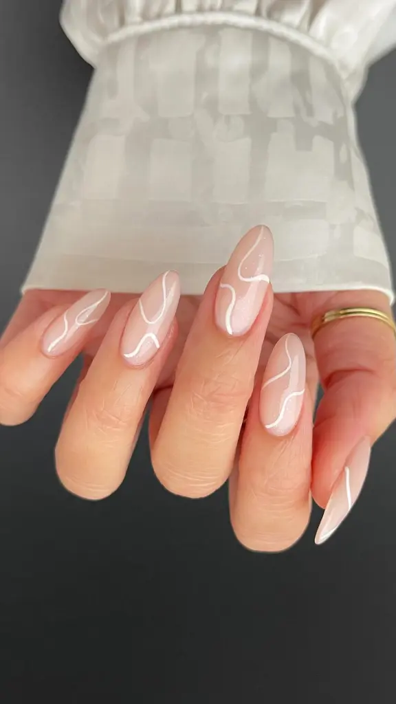 Almond-shaped minimalist nails with milky nude base and asymmetrical white curved line details