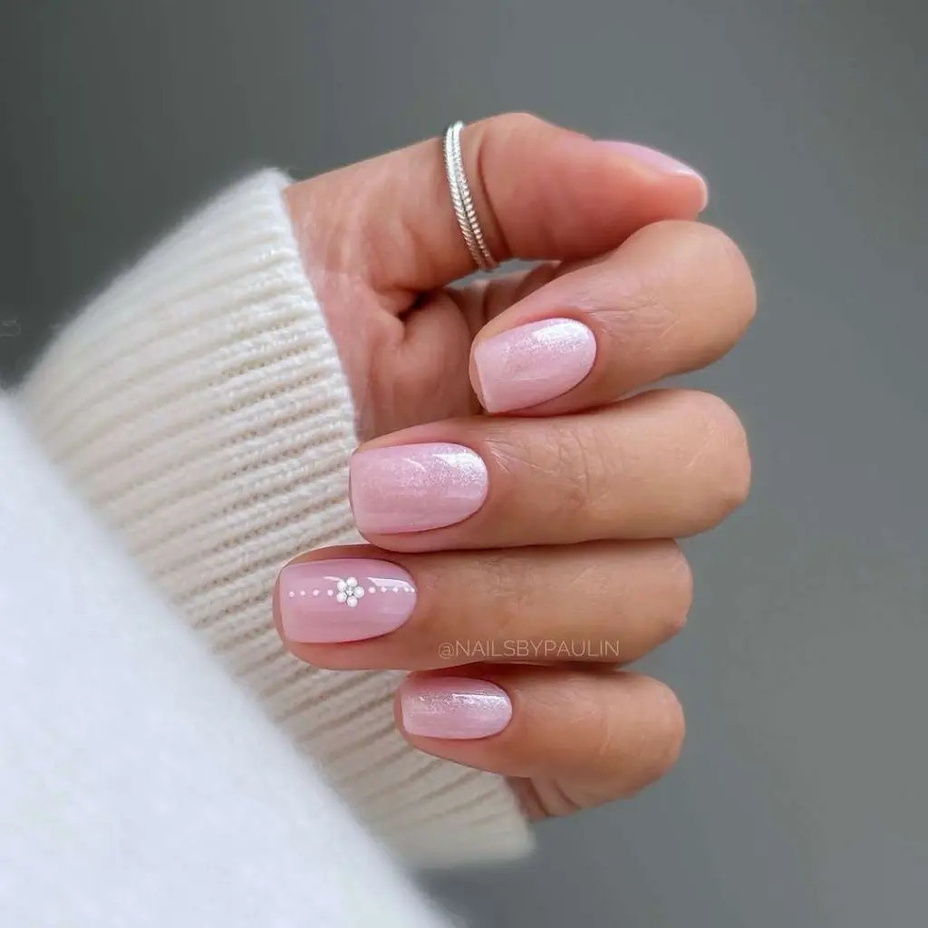 Short square pink iridescent nails with white daisy flower accent nail design for elegant spring manicure