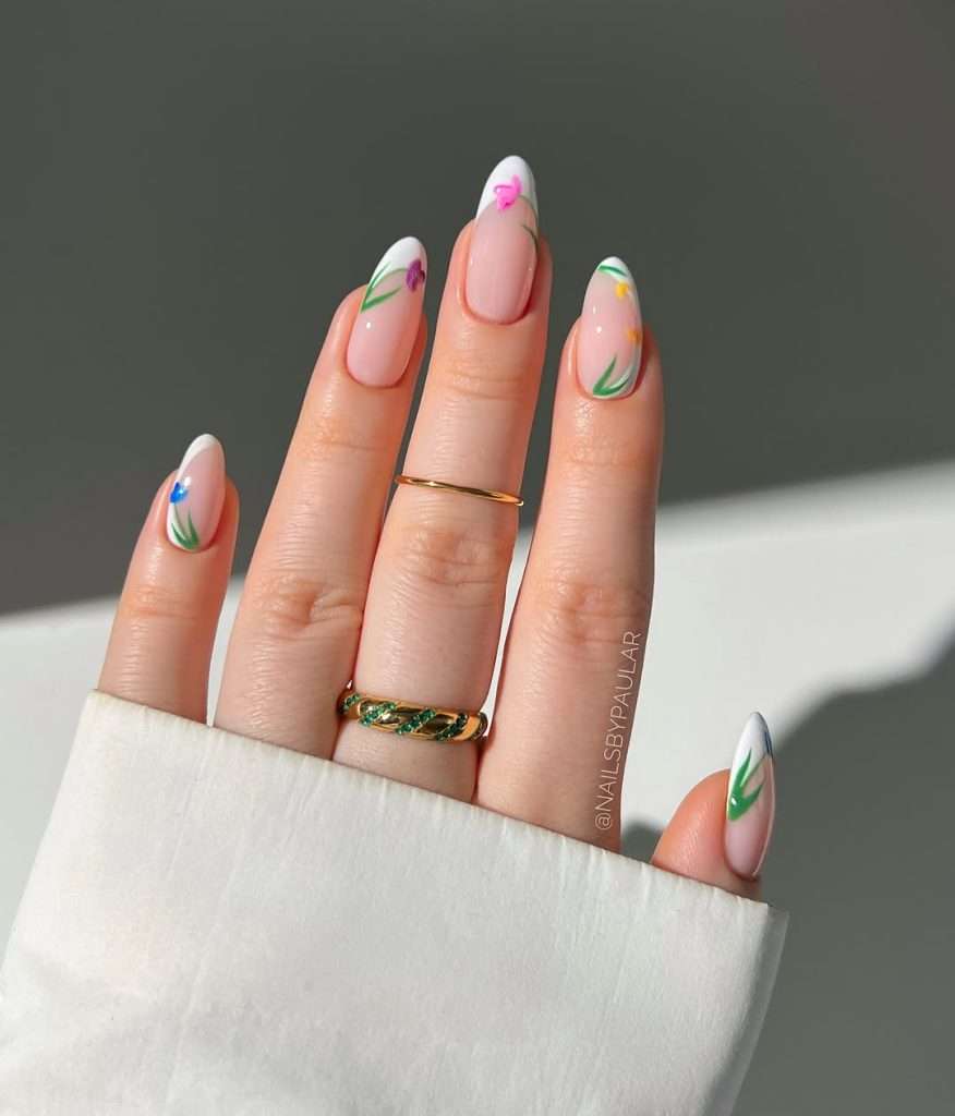 spring almond nails with pink base, white tips and multicolored tulip designs
