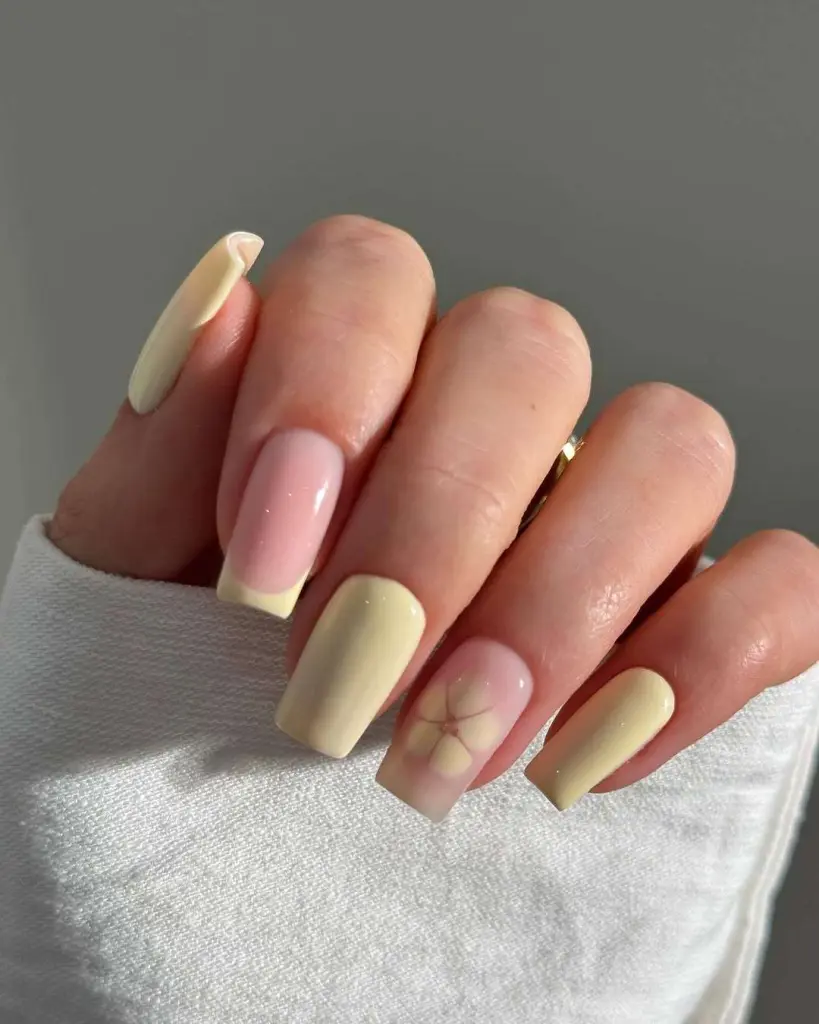 Long square nails with alternating soft yellow and sheer pink base featuring flower outline accent nail for elegant spring manicure