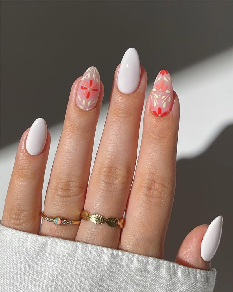 almond summer nails with alternating white polish and soft pink base with coral flower art and gold accent details

