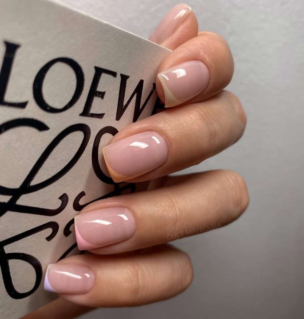 Short square nails with nude pink base and diagonal pastel French tips
