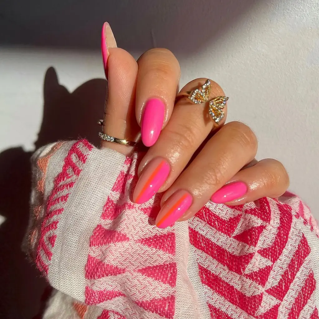 Almond summer nails with hot pink polish and orange vertical stripe accent design
