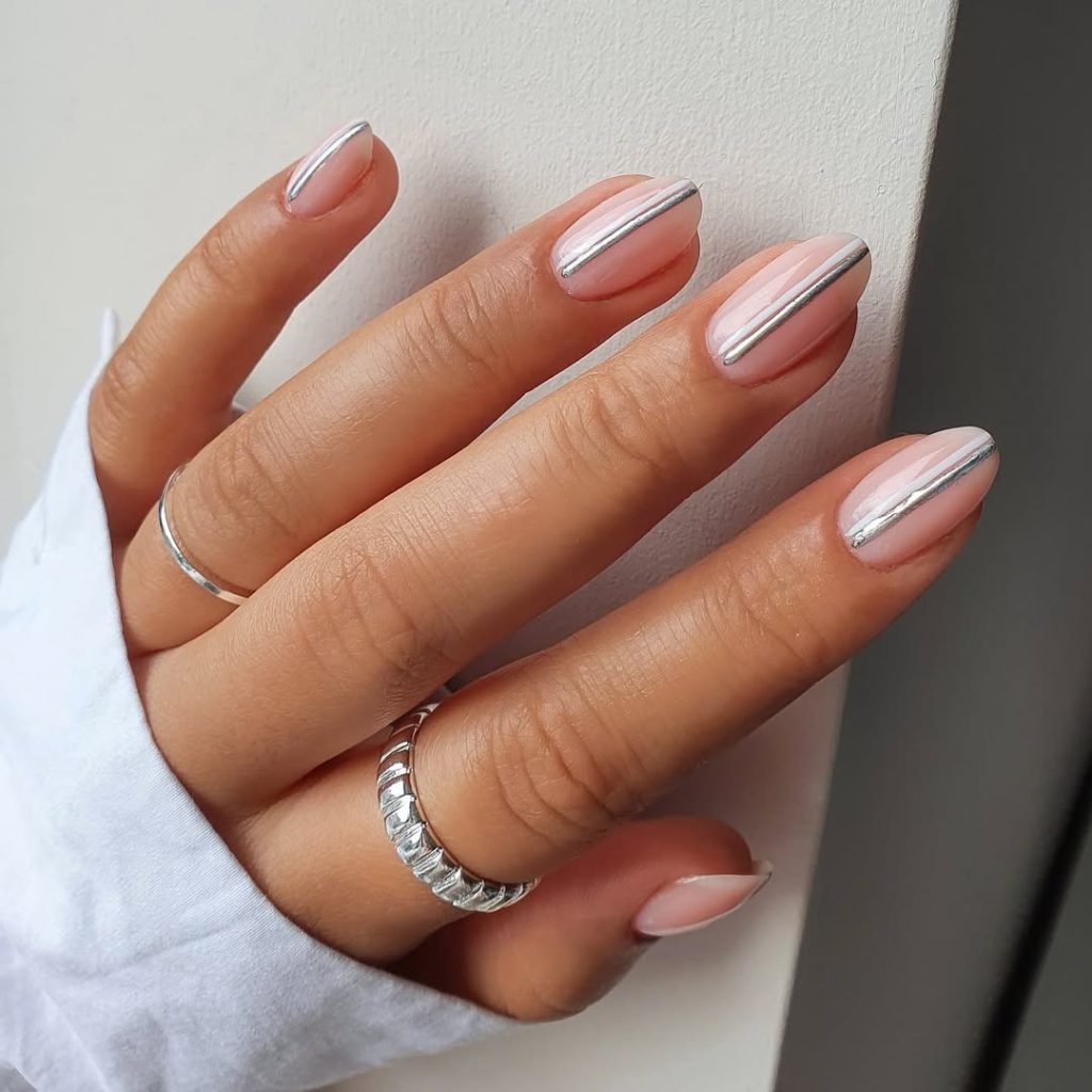 Short oval minimalist nails with sheer pink base and vertical silver chrome stripe with white line accent