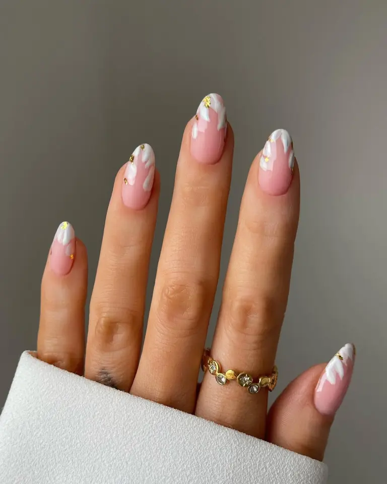 Almond shaped graduation nails with pink base, white marble swirl French tips and scattered gold foil accents