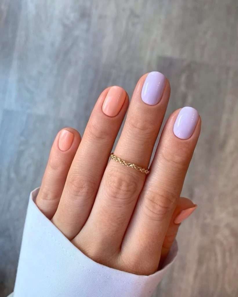 Short square nails in alternating peach and light lilac colors with high-shine finish