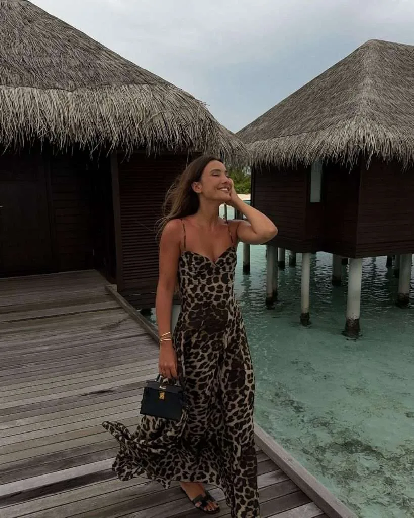 Beach resort outfit with leopard print spaghetti strap maxi dress, black structured mini handbag, gold bracelet and black sandals