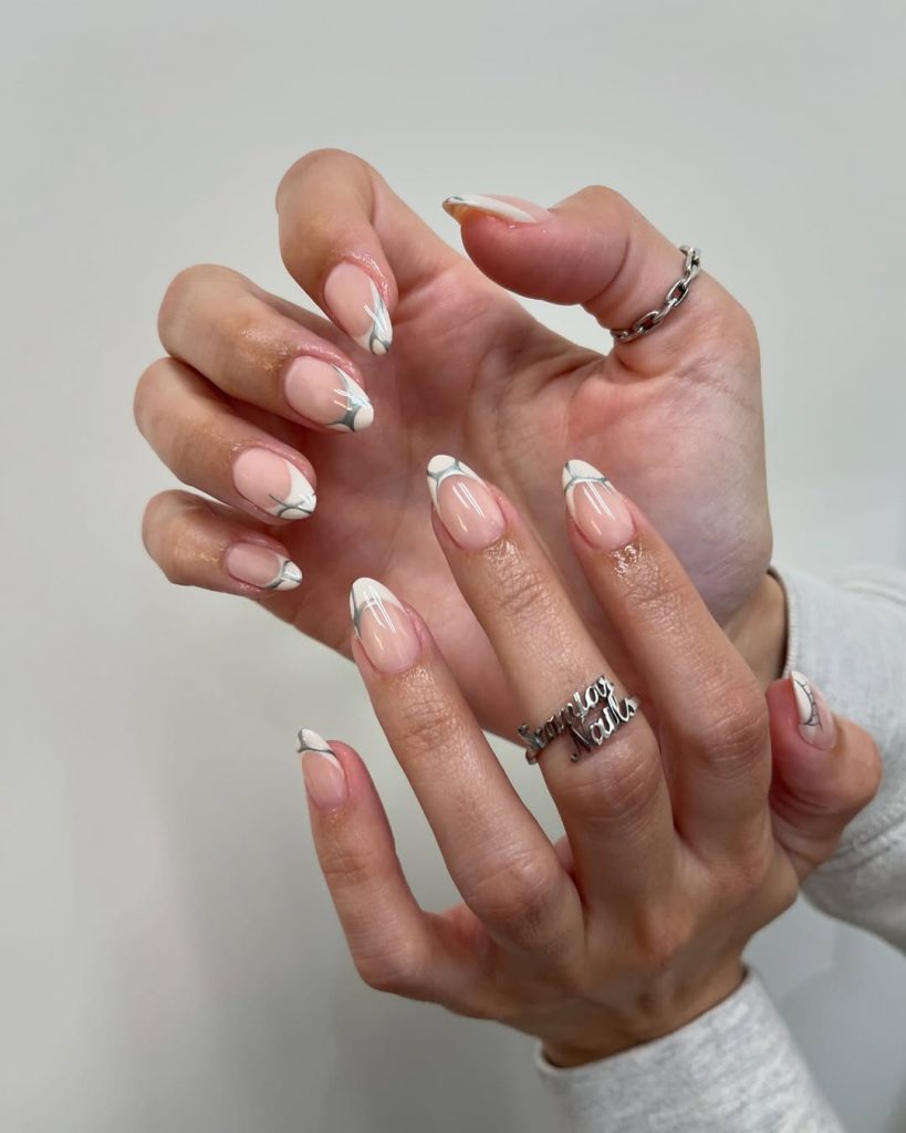 Almond shaped pink nails with white French tips and silver abstract line accents