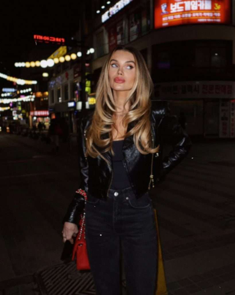 Edgy spring date night outfit with black leather jacket, black top, black jeans and bright red handbag
