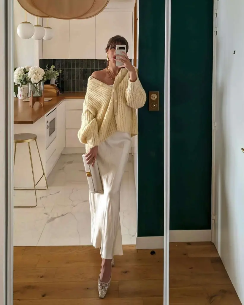 Romantic spring date night outfit with pale yellow oversized cardigan, white silk slip dress, cream pointed heels and clutch