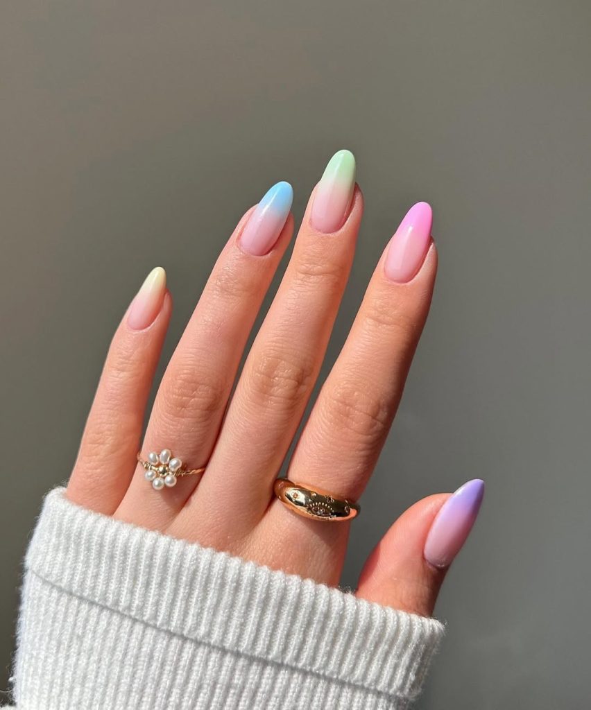 Almond summer nails with nude base and different pastel colored tips including yellow, blue, mint, pink and lavender