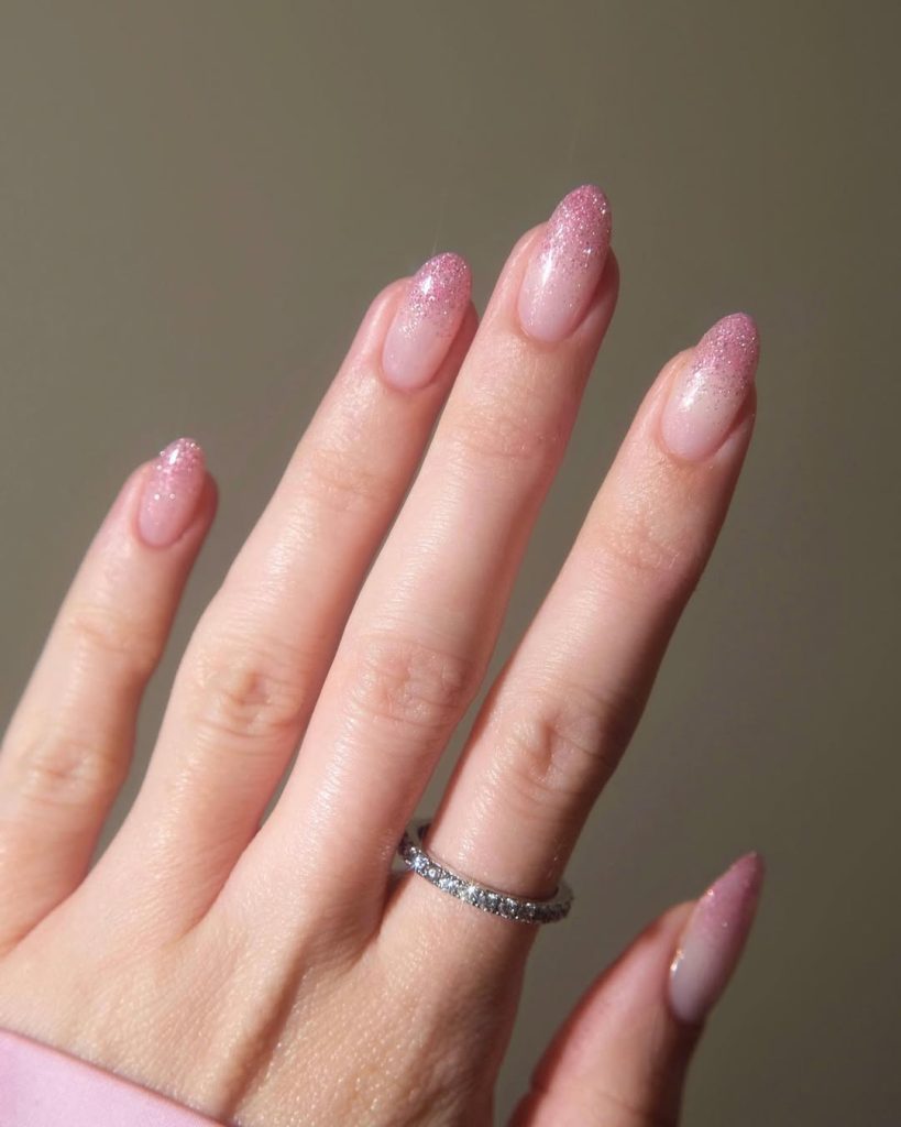 Almond shaped pink nails with pink glitter gradient tips