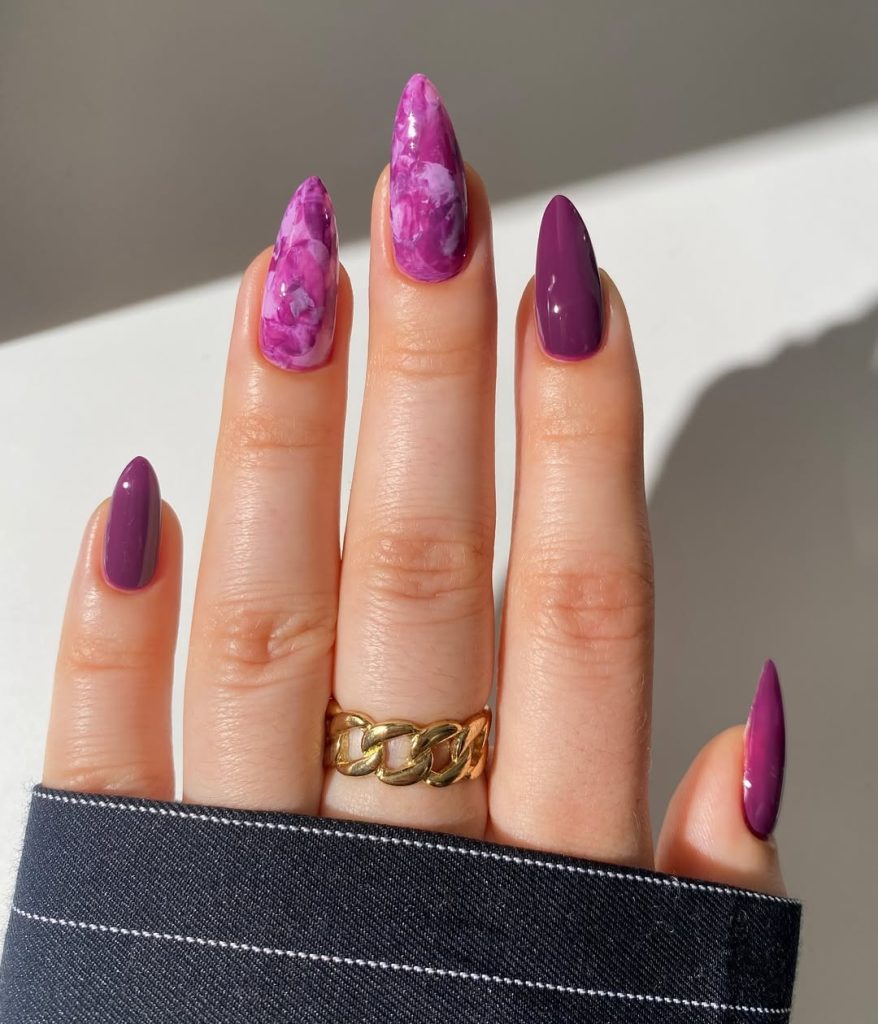 almond summer nails with deep plum purple polish and vibrant purple marble design
