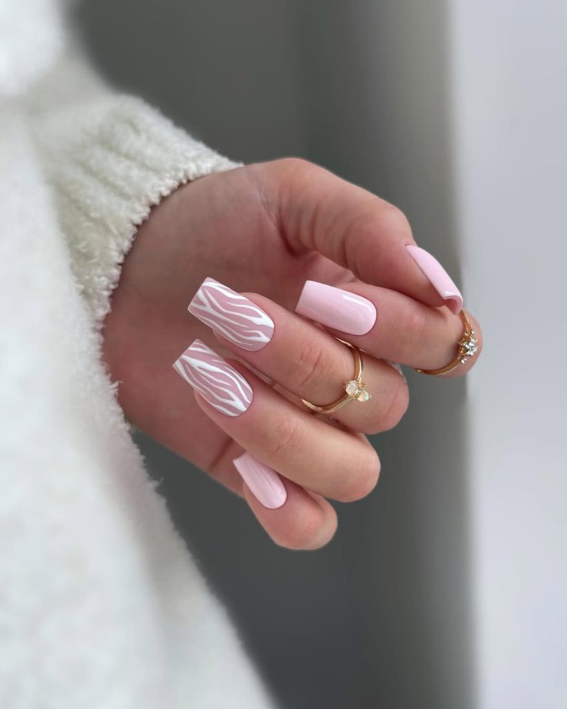 Square minimalist nails with milky pink base and white zebra pattern accent on middle and ring fingers
