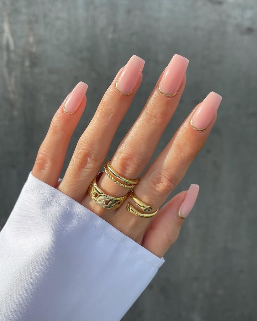square shaped matte pink nails with gold curved accent lines at cuticle
