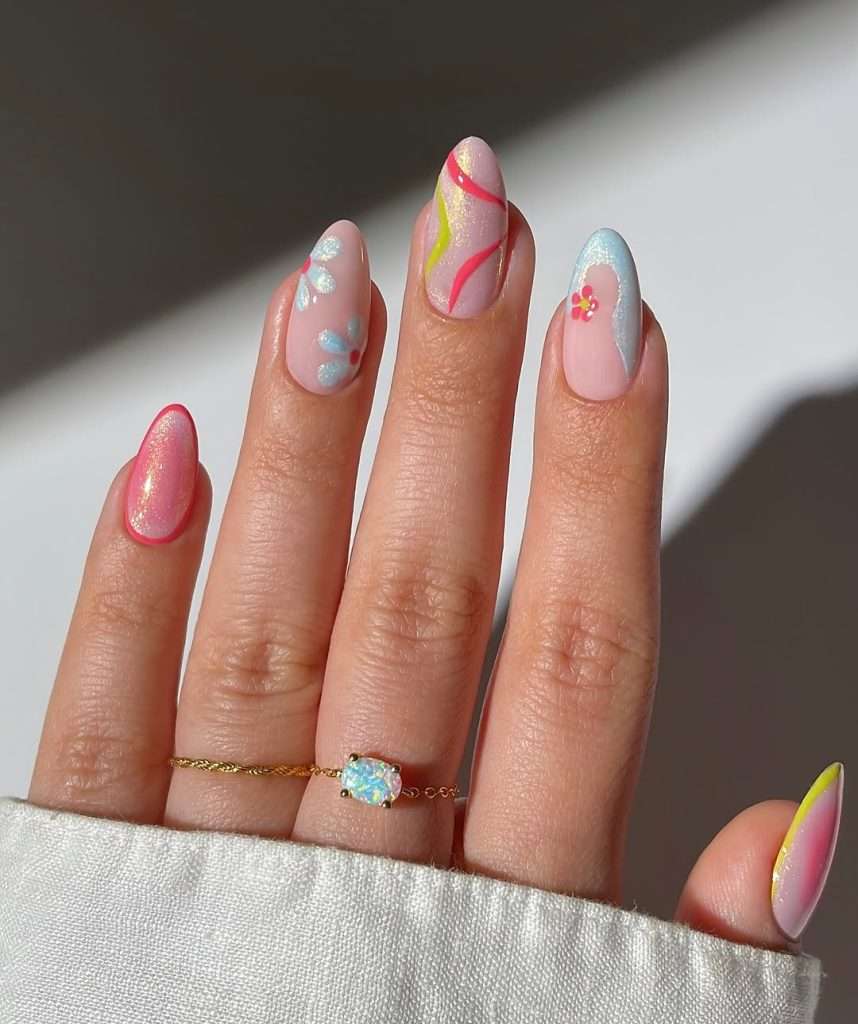 spring nails with shimmery pink base and abstract design in coral, yellow and blue with floral accents
