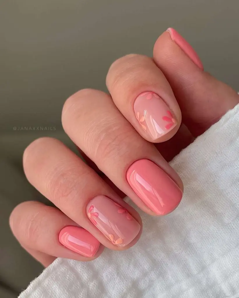 Short spring nails with alternating sheer pink and coral polish with small floral accents