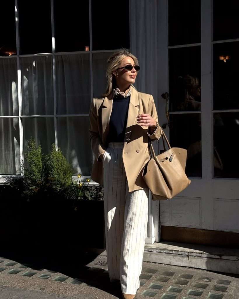 old money spring outfit with camel blazer, navy sweater, white pinstripe trousers, printed silk scarf and tan leather tote
