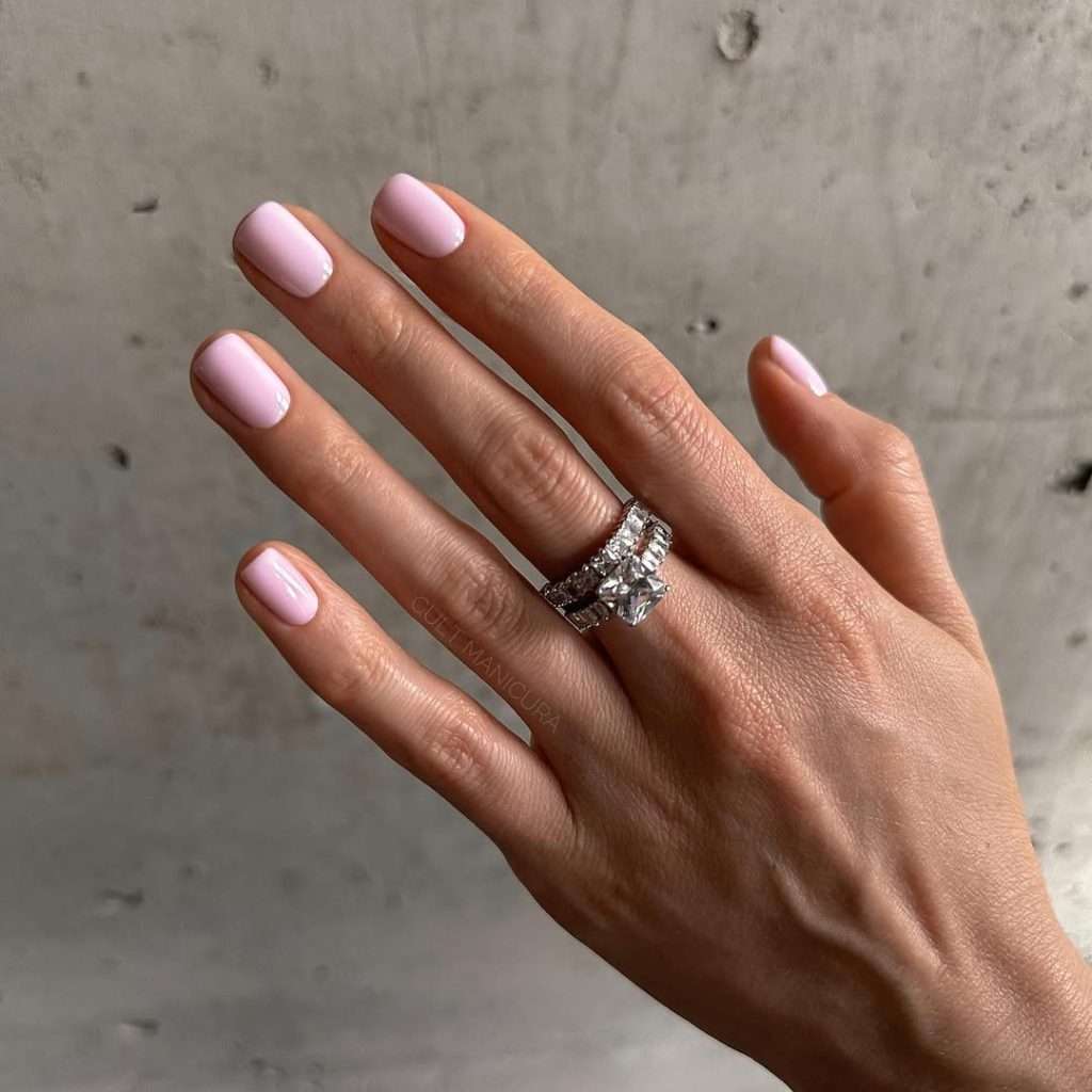 Short square nails in glossy soft pink polish with clean minimal finish