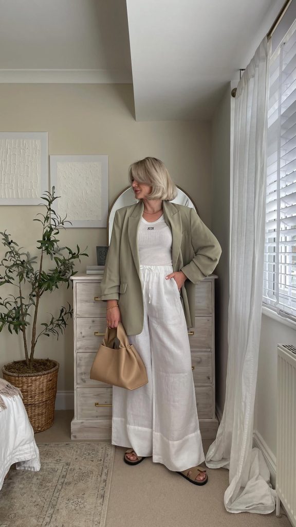 Elegant outfit with sage green blazer, white ribbed tank top, white wide-leg linen pants, beige leather tote and brown sandals