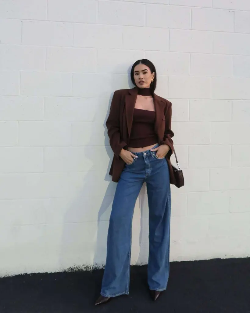  Casual spring date night outfit with chocolate brown blazer, matching crop top, wide-leg blue jeans and small brown handbag
