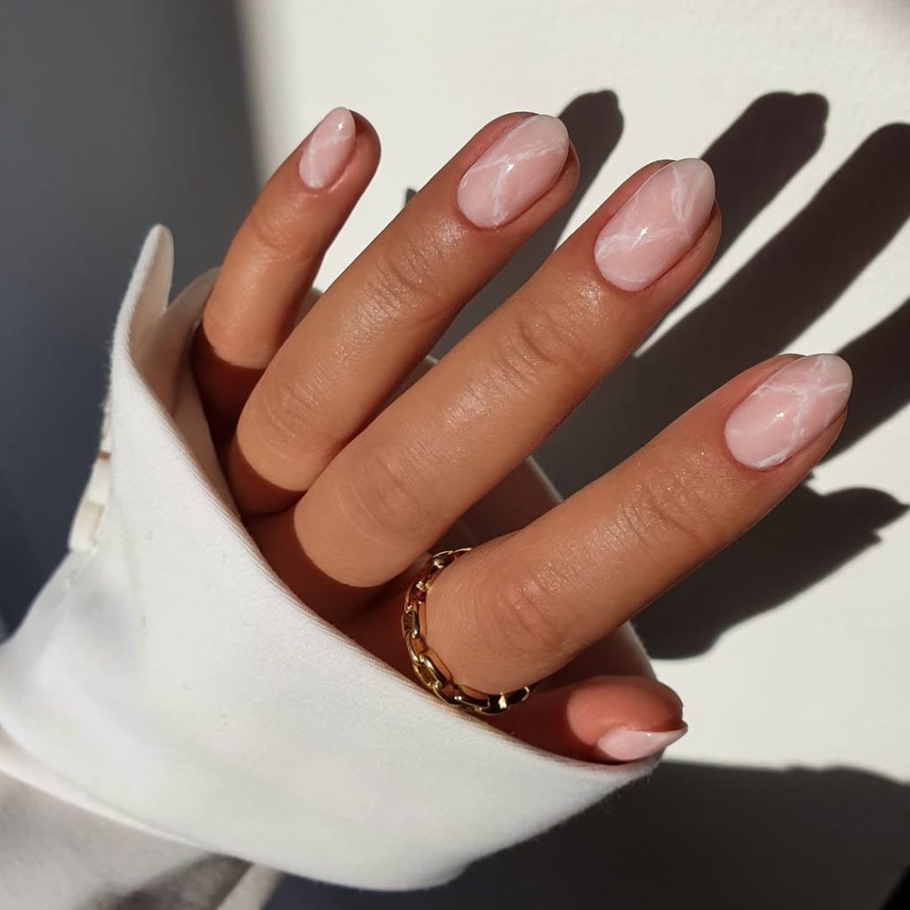 oval minimalist nails with translucent pink base and subtle white marble effect throughout