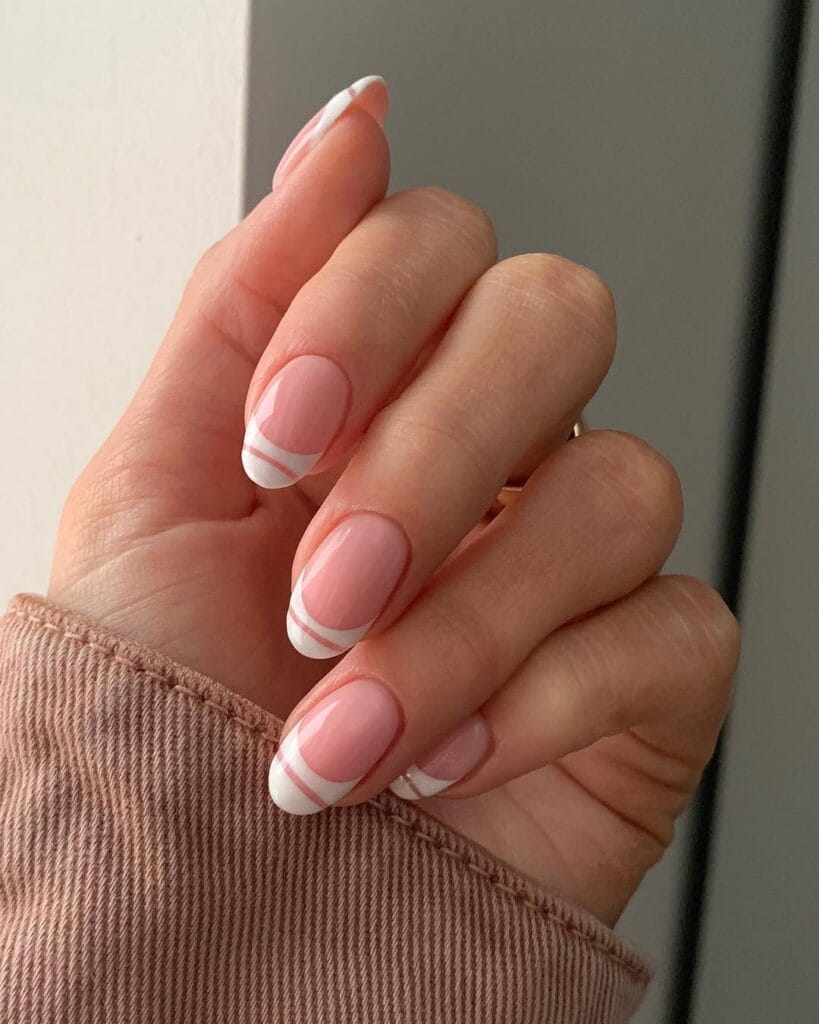 Oval minimalist nails with pink base and double parallel white line French tip detail