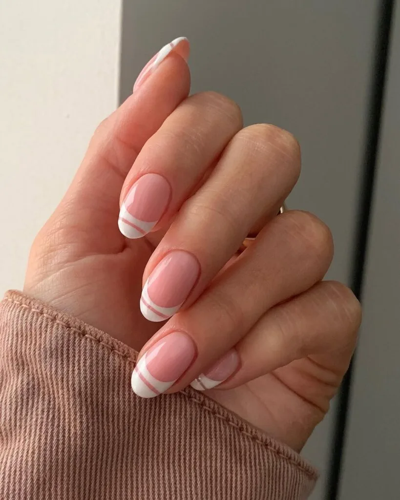 Oval minimalist nails with pink base and double parallel white line French tip detail