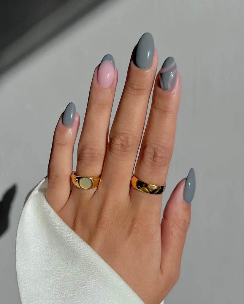 Almond minimalist nails with grey solid polish, one pink accent nail, and grey swirl detail