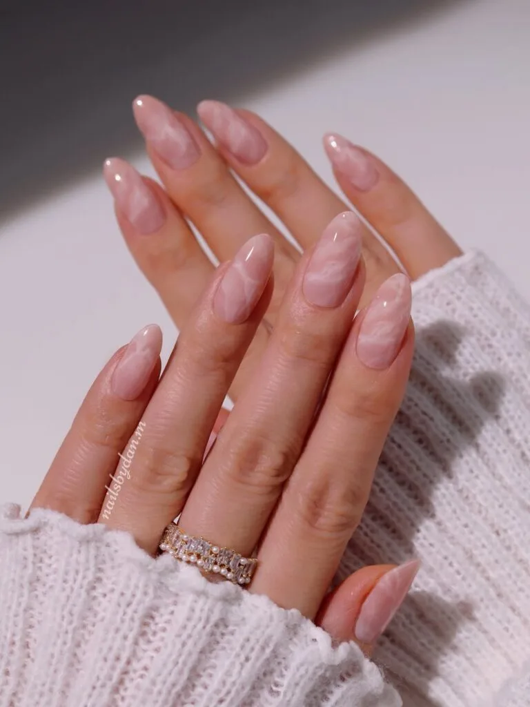  Almond minimalist nails with nude pink base and subtle white marble swirl pattern