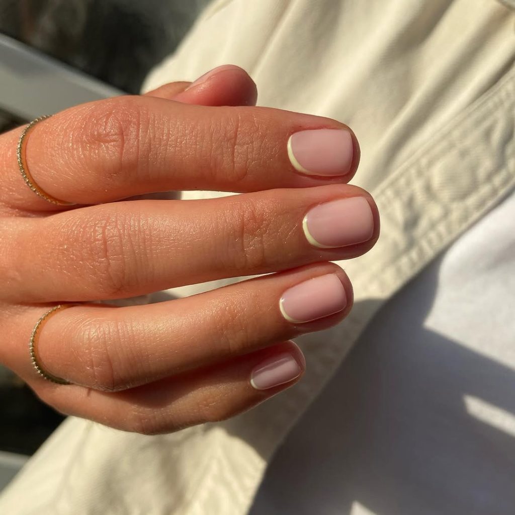 old money summer natural nails with sheer pink base and thin pastel yellow line along the cuticle area