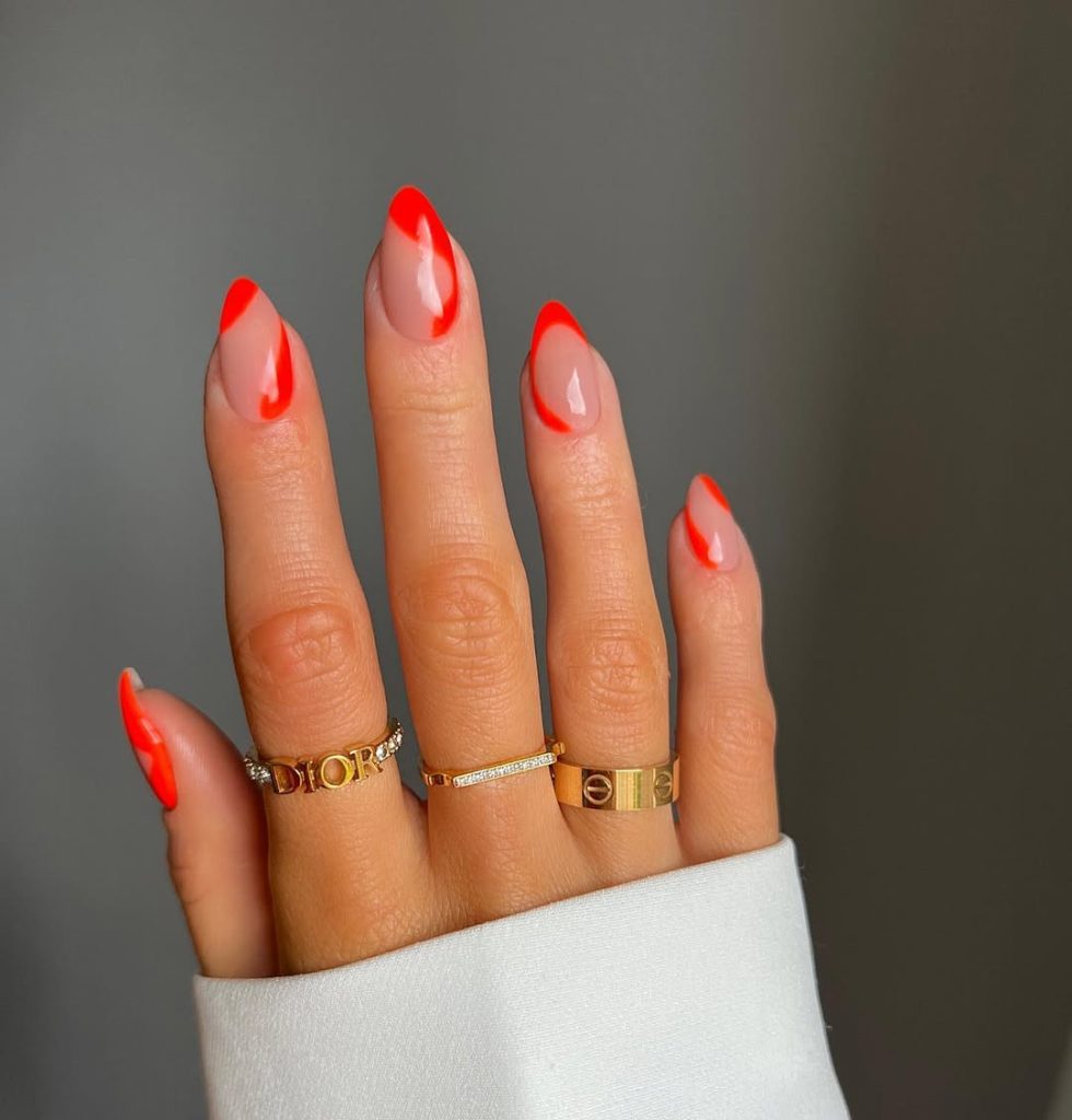 Almond shaped nude nails with bright red outline details and glossy finis
