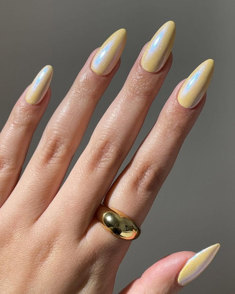 Long almond vacation nails with yellow chrome holographic finish
